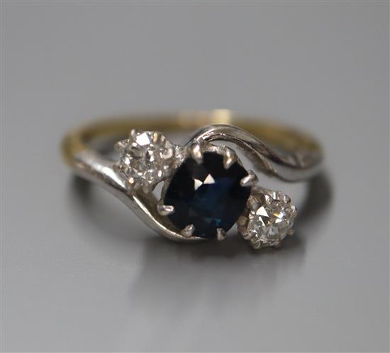 An 18ct, sapphire and diamond three stone crossover ring, size K.